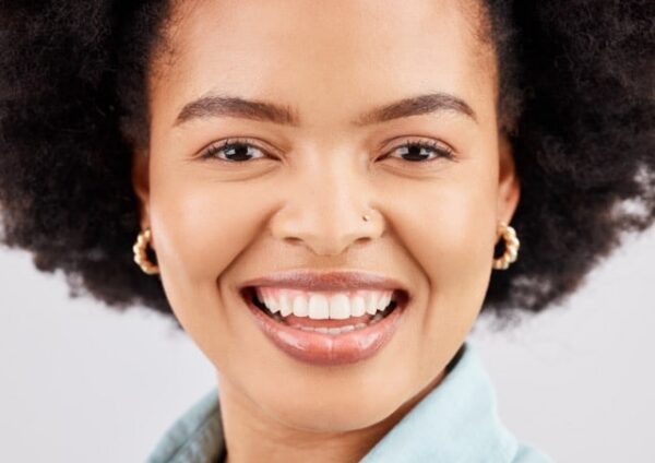 Face, happy and portrait of black woman in studio with smile, confidence and happiness on white bac.